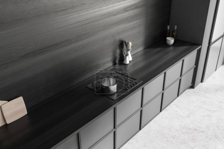 Téléchargez les photos : Vue de dessus de l'intérieur de la cuisine sombre avec cuisinière et terrasse en bois noir, réfrigérateur et ustensiles de cuisine minimalistes. Coin cuisine avec sol en béton gris. rendu 3D - en image libre de droit