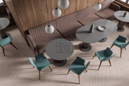 Photo for Top view of stylish cafe interior with dark wooden walls, wooden floor, comfortable round and oval gray tables with blue chairs and soft brown sofas. 3d rendering - Royalty Free Image
