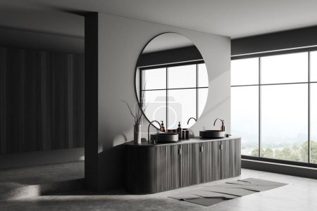 Photo for Dark bathroom interior with double sink and dresser with accessories, side view, grey concrete floor. Panoramic window on countryside. 3D rendering - Royalty Free Image