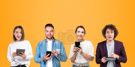 Foto de Cuatro estudiantes de negocios sonrientes trabajando juntos, retratos en fila en el espacio de copia fondo naranja. Uso de dispositivos digitales para la comunicación y la red. Concepto de conexión en línea y educación - Imagen libre de derechos