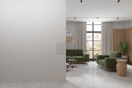 Foto de Acogedor interior de la sala de estar del hotel con sofá verde y sillón, mesa de centro con decoración. Espejo, planta y ventana panorámica en el resort. Simular la pared partición vacía. Renderizado 3D - Imagen libre de derechos