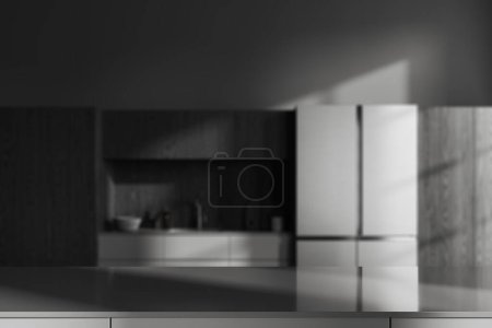 Foto de Mesa de presentación producto gris de pie en la cocina loft borrosa con paredes grises, armarios de madera oscura, nevera grande y armarios grises con fregadero incorporado. 3d renderizado, espacio de copia - Imagen libre de derechos