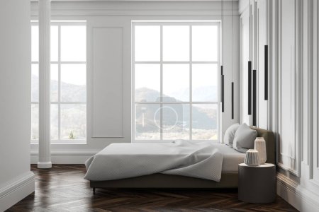 Foto de Interior de dormitorio moderno en estilo clásico con paredes blancas, suelo de madera, columna, cómoda cama king size con manta blanca y mesa de noche redonda de pie cerca de dos ventanas. renderizado 3d - Imagen libre de derechos