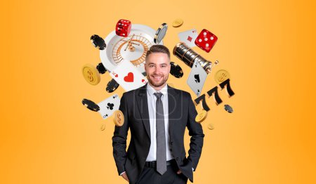 Photo for Happy businessman portrait standing with hands in pocket, roulette and casino poker cards with money falling on orange background. Concept of online game, win and success - Royalty Free Image