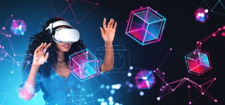 Portrait of young African woman in VR virtual reality headset working with immersive blockchain interface in metaverse. Concept of cyberspace and information fields