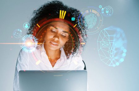 Téléchargez les photos : Femme d'affaires occupée noire travaillant avec ordinateur portable, hologramme de hud de balayage biométrique lumineux, détection du visage et intelligence artificielle. Concept de connexion numérique - en image libre de droit