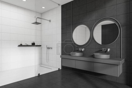 Téléchargez les photos : Vue d'angle sur l'intérieur sombre de la salle de bain avec douche, murs blancs et gris, sol carrelage en béton, deux miroirs ronds et double vasque, cloison en verre, étagère avec shampooing. Rendu 3d - en image libre de droit