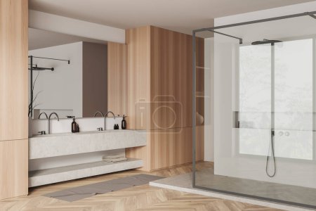 Foto de Interior de baño de madera con doble lavabo y espejo, ducha vista lateral detrás de la partición de vidrio. Cubierta de piedra con accesorios de baño, toalla de pie en el suelo de madera. Renderizado 3D - Imagen libre de derechos