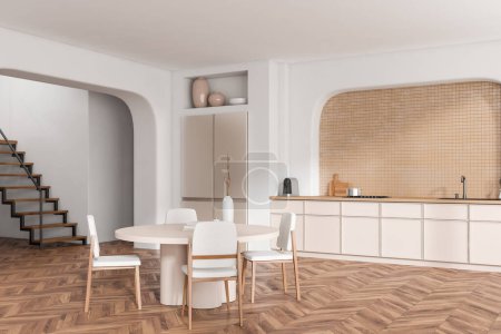 Foto de Interior de la cocina blanca con mesa de comedor y sillas, estantes con vista lateral con utensilios de cocina y nevera en el suelo de madera. Escaleras en apartamento moderno. Renderizado 3D - Imagen libre de derechos