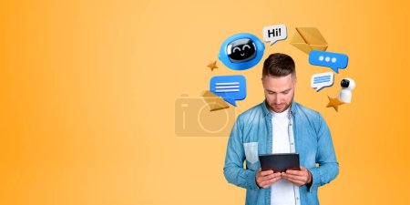 Photo for Smiling man looking at tablet in hands, digital robot icon with text and speech bubbles, empty orange background. Concept of AI conversation, social media and technology - Royalty Free Image