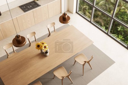 Téléchargez les photos : Vue de dessus de la cuisine moderne avec des murs beiges, sol en béton, armoires en bois confortables avec cuisinière intégrée et longue table à manger avec chaises. Rendu 3d - en image libre de droit