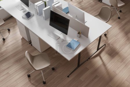 Foto de Vista superior del interior de coworking con monitores de pc en la mesa con partición, tecnología y muebles minimalistas en suelo de madera. Elegante lugar de trabajo con herramientas y tecnología. Renderizado 3D - Imagen libre de derechos