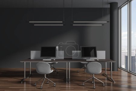 Foto de Interior coworking oscuro con sillones y monitores de pc en el escritorio con partición, suelo de madera. Espacio de trabajo de la oficina corporativa y ventana panorámica de los rascacielos de Nueva York. Renderizado 3D - Imagen libre de derechos