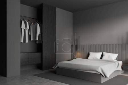 Photo for Corner of stylish bedroom with gray walls, concrete floor, comfortable king size bed and big open wardrobe with clothes hanging inside. 3d rendering - Royalty Free Image
