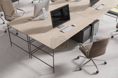 Foto de Vista superior del interior de coworking con ordenadores PC en escritorio de madera, sillones en fila en piso de hormigón ligero. Elegante espacio de trabajo con muebles minimalistas para el trabajo en equipo. Renderizado 3D - Imagen libre de derechos