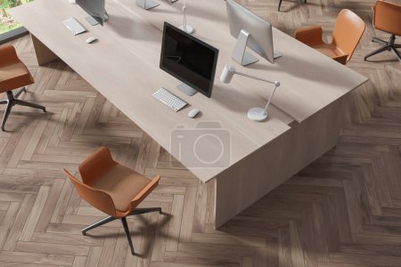 Téléchargez les photos : Vue de dessus de l'intérieur de coworking en bois avec PC de bureau sur la table de travail, plancher de bois franc. Coin de travail élégant avec un mobilier et une technologie minimalistes. rendu 3D - en image libre de droit