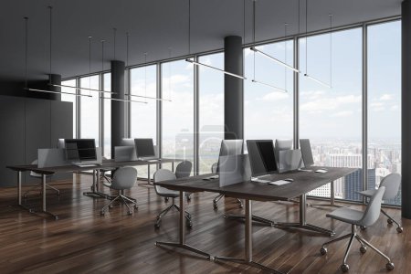 Foto de Moderno interior de coworking con sillas y ordenador PC en fila en el escritorio, vista lateral piso de hormigón gris. Oficina de negocios y ventana panorámica de los rascacielos de Nueva York. Renderizado 3D - Imagen libre de derechos