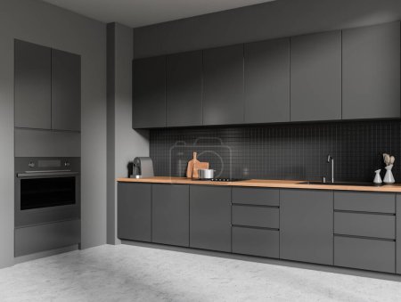 Photo for Dark kitchen interior with kitchenware on deck, side view grey concrete floor. Cooking corner with minimalist appliances and oven mounted. 3D rendering - Royalty Free Image