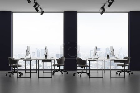 Foto de Interior oscuro coworking con ordenadores PC y sillones en fila, suelo de hormigón ligero. Elegante espacio de trabajo con ventana panorámica sobre los rascacielos de París. Renderizado 3D - Imagen libre de derechos
