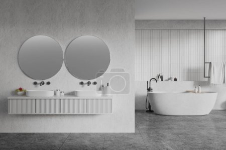 Téléchargez les photos : Intérieur de la salle de bain de l'hôtel blanc avec double lavabo, cloison et baignoire avec accessoires. Vanité flottante, porte-serviettes et mélangeur montés sur sol en béton carrelé gris. rendu 3D - en image libre de droit