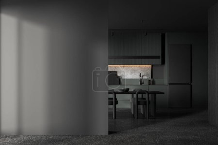 Téléchargez les photos : Intérieur de cuisine sombre avec table et chaises, sol en béton gris. Espace de cuisson avec étagères d'armoire cachées, réfrigérateur et cloison murale maquillée. rendu 3D - en image libre de droit