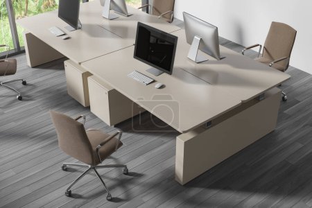 Foto de Vista superior del interior de coworking con monitores de pc en el escritorio, sillones en piso de madera gris. Elegante oficina de trabajo con muebles minimalistas y tecnología. Renderizado 3D - Imagen libre de derechos
