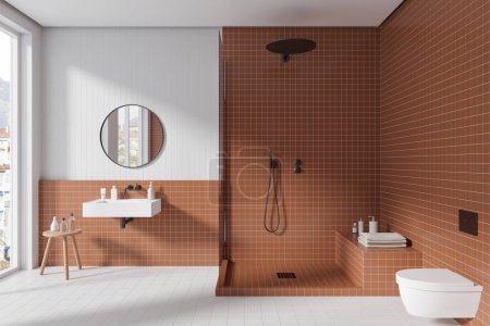 Téléchargez les photos : Salle de bain intérieure de l'hôtel blanche et marron avec lavabo et douche, toilettes suspendues murales et fenêtre panoramique. Bouteilles de bain minimalistes serties de serviette. rendu 3D - en image libre de droit