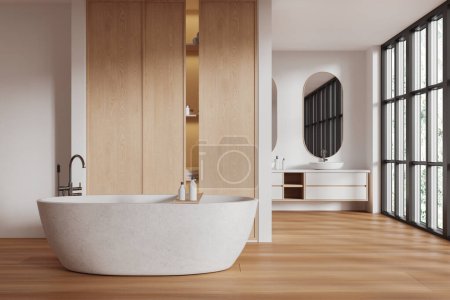 Téléchargez les photos : Intérieur de salle de bain d'hôtel blanc et en bois avec baignoire et lavabo, cloison d'étagère. Espace de bain avec mobilier élégant et fenêtre panoramique sur les tropiques. rendu 3D - en image libre de droit