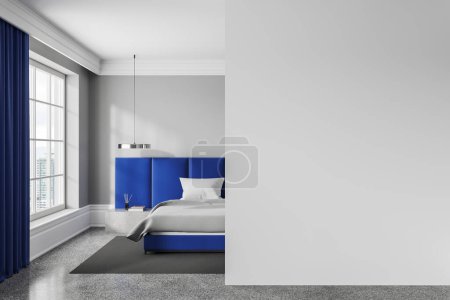 Foto de Interior de dormitorio moderno con paredes grises, suelo de hormigón, cómoda cama king size azul, mesita de noche masiva y pared de espacio de copia blanca a la derecha. renderizado 3d - Imagen libre de derechos