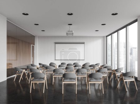 Foto de Interior de la moderna sala de conferencias con paredes blancas y de vidrio, suelo de hormigón, filas de sillas grises y pantalla de proyección simulada. Formación empresarial y concepto de conferencia. renderizado 3d - Imagen libre de derechos