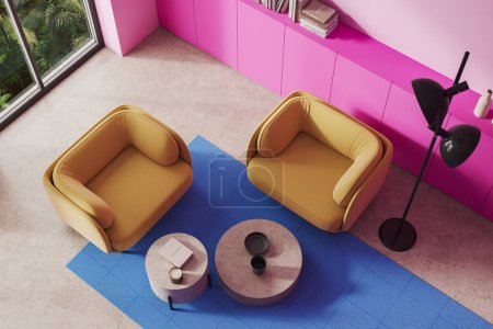 Foto de Vista superior de la moderna sala de estar con paredes de color rosa, suelo de piedra, dos cómodos sillones amarillos de pie cerca de dos mesas de café redondas y vestidor rosa. renderizado 3d - Imagen libre de derechos