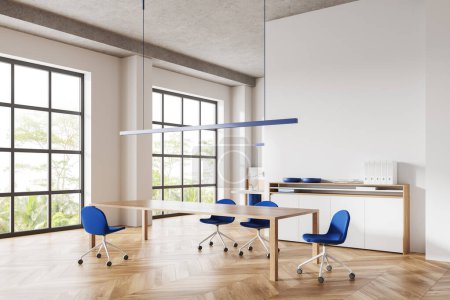 Foto de Interior de la sala de reuniones blanca con mesa de madera y sillas azules, aparador con vista lateral y decoración. Esquina de negociación con muebles mínimos y ventana panorámica en los trópicos. Renderizado 3D - Imagen libre de derechos