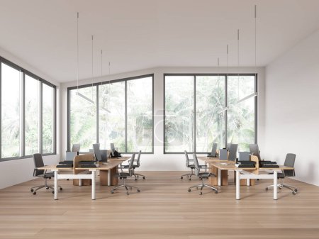 Foto de Interior de loft de oficina blanco con monitores de pc, espacio de coworking con sillones y escritorio en fila en suelo de madera. Espacio de trabajo minimalista con muebles y ventana panorámica. Renderizado 3D - Imagen libre de derechos