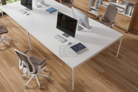 Téléchargez les photos : Vue de dessus de l'intérieur de bureau moderne avec plancher en bois et table d'ordinateur blanche massive avec chaise brune debout près de lui. Rendu 3d - en image libre de droit