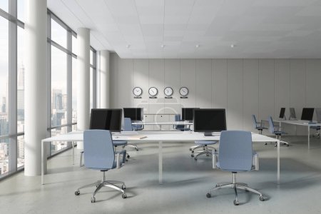 Foto de Blanco acogedor interior de la oficina con sillones y ordenadores PC en el escritorio, piso de hormigón. Elegante espacio de coworking con aparador, reloj mundial y ventana panorámica en Kuala Lumpur. Renderizado 3D - Imagen libre de derechos