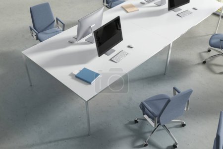 Foto de Vista superior del interior de coworking con ordenadores PC en el escritorio, sillones azules en el suelo de hormigón ligero. Moderno lugar de trabajo de oficina con muebles minimalistas para el trabajo en equipo. Renderizado 3D - Imagen libre de derechos