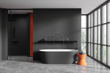 Téléchargez les photos : Intérieur de la salle de bain élégante avec des murs gris, sol carrelé, douche à l'italienne et confortable baignoire grise debout près de la grande fenêtre. Rendu 3d - en image libre de droit