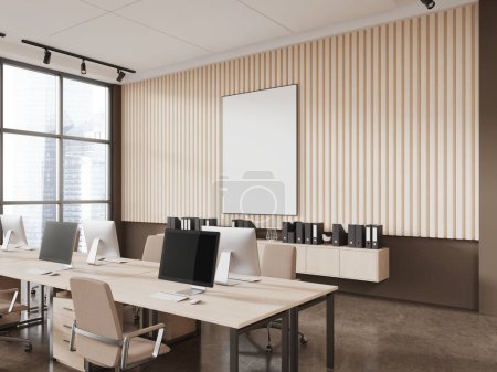 Foto de Esquina de la moderna oficina de espacio abierto con paredes de color beige y marrón, piso de hormigón, fila de mesas de ordenador con sillas beige y la maqueta vertical de póster. renderizado 3d - Imagen libre de derechos