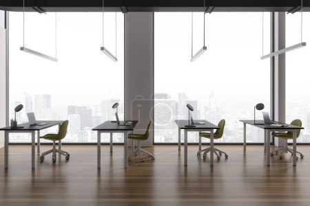 Foto de Elegante interior de oficina con sillones y escritorio en fila, piso de madera. Espacio de aprendizaje, biblioteca o sala de negocios con ordenador portátil y ventana panorámica de los rascacielos de París. Renderizado 3D - Imagen libre de derechos