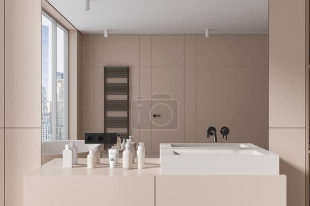 Téléchargez les photos : Intérieur de la salle de bain moderne avec des murs beiges, élégant lavabo blanc debout sur le comptoir beige avec des crèmes et des articles de toilette et grand miroir suspendu au-dessus. Rendu 3d - en image libre de droit
