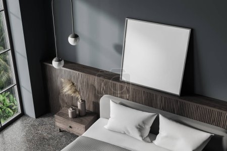Foto de Vista superior de la cama interior del dormitorio en casa y mesita de noche con decoración, suelo de granito gris. Esquina de dormir con el póster de lona simulada y ventana panorámica. Renderizado 3D - Imagen libre de derechos