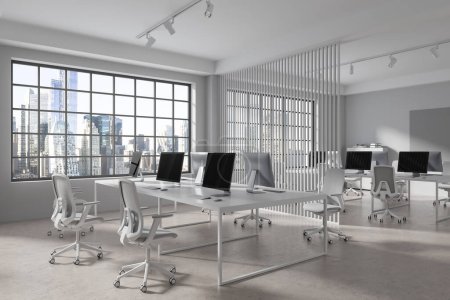 Foto de Moderno interior de oficina con sillones y ordenadores PC en fila, vista lateral piso de hormigón ligero. Espacio de trabajo minimalista con partición y ventana panorámica en rascacielos. Renderizado 3D - Imagen libre de derechos