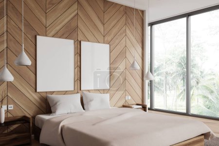 Foto de Acogedora cama interior del dormitorio y ventana panorámica, mesita de noche con decoración en suelo de madera. Esquina de sueño beige con dos carteles de lona simulados en fila. Renderizado 3D - Imagen libre de derechos