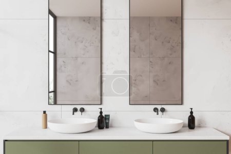 Téléchargez les photos : Intérieur de la salle de bain moderne avec des murs en marbre blanc et confortable évier blanc double debout sur armoire verte avec deux miroirs verticaux suspendus au-dessus. Rendu 3d - en image libre de droit