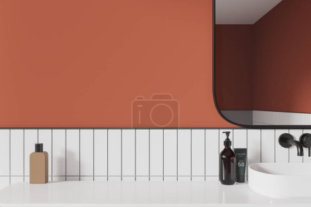 Téléchargez les photos : Intérieur de salle de bain moderne avec des murs carrelés orange et blanc, lavabo et miroir confortables et plateau d'affichage de produits blancs pour les cosmétiques et les produits d'hygiène. Rendu 3d - en image libre de droit