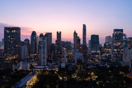 Téléchargez les photos : Vue panoramique du paysage urbain de Bangkok avec des fenêtres et des arbres de gratte-ciel lumineux en soirée. Concept de tourisme, d'affaires et de voyage en Thaïlande - en image libre de droit