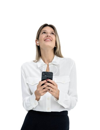 Foto de Mujer de negocios sonriente usando el teléfono, feliz mirando hacia arriba con auriculares, escuchando música o podcast. Aislado sobre fondo blanco. Concepto de comunicación en línea, redes y redes sociales - Imagen libre de derechos