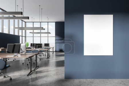 Foto de Interior de elegante oficina de espacio abierto con paredes azules, suelo de hormigón, enormes escritorios de ordenador con sillas azules y ventanas panorámicas con paisaje urbano. Una maqueta vertical de póster. renderizado 3d - Imagen libre de derechos