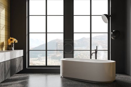 Téléchargez les photos : Intérieur sombre de la salle de bain de l'hôtel avec baignoire et vanité élégante, lampe au sol en granit gris. Espace de baignade avec décoration et fenêtre panoramique sur campagne. rendu 3D - en image libre de droit