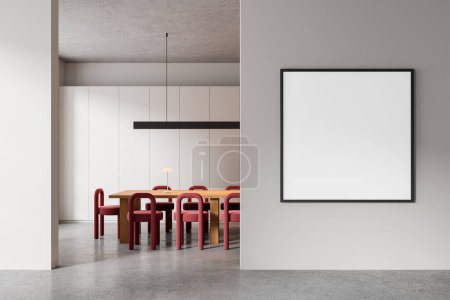 Foto de Acogedor interior de la conferencia con sillas rojas y mesa de madera, piso de hormigón gris. Espacio de reunión con muebles elegantes, póster de lona cuadrada maqueta en la partición. Renderizado 3D - Imagen libre de derechos